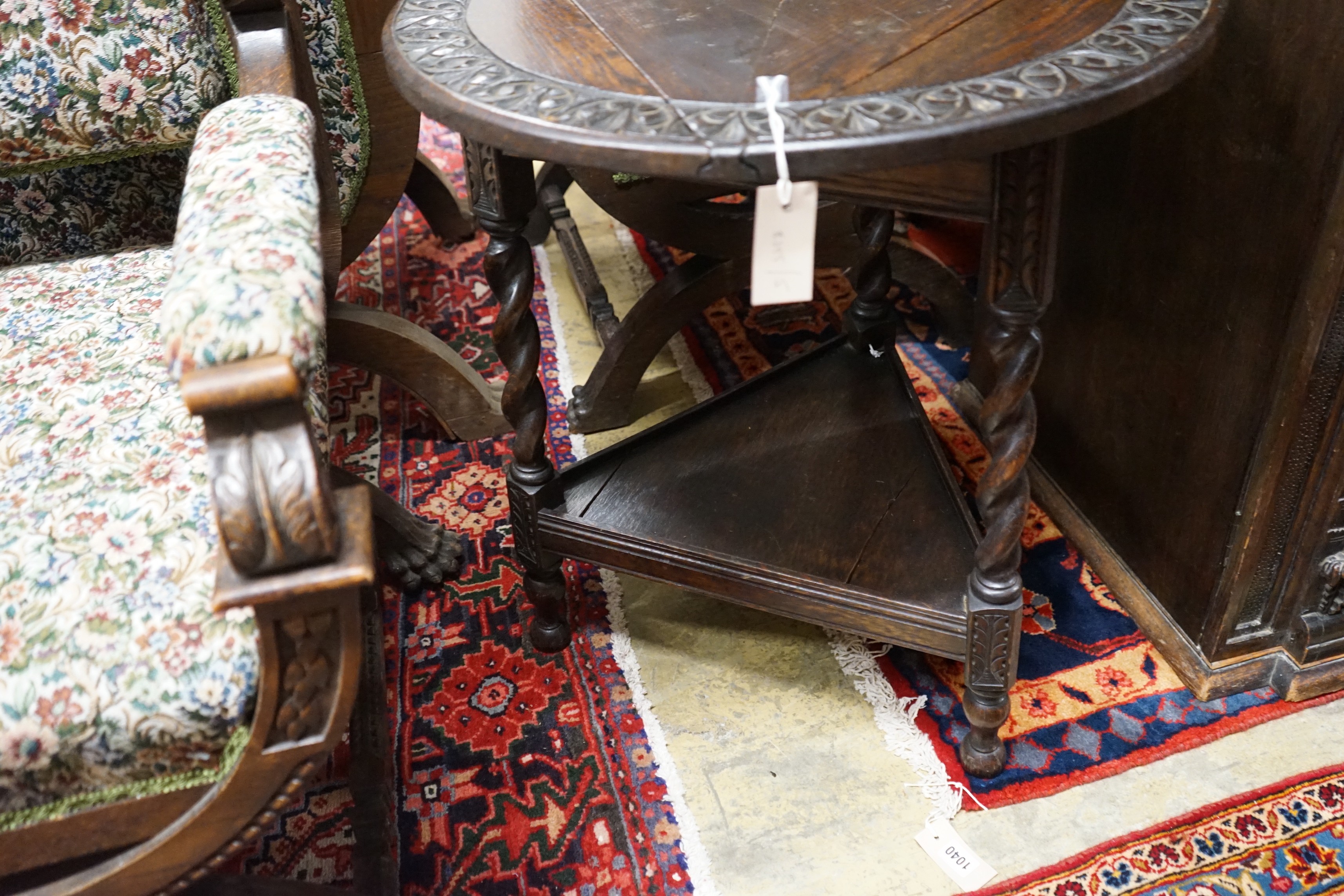 A 1920's circular oak drop flap two tier occasional table, diameter 61cm, height 69cm